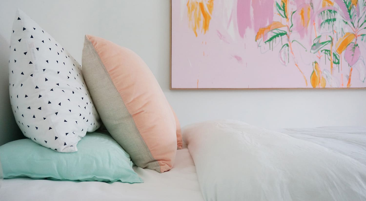 Photo of colourful painting above designer bed